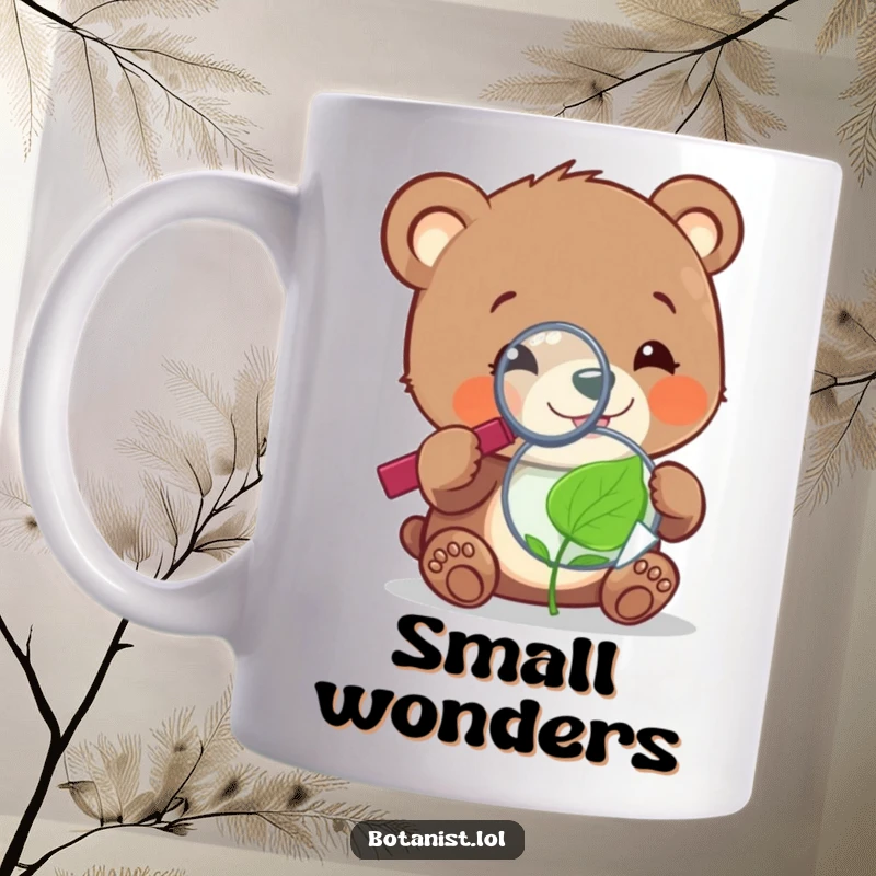 Funny, cheerful bear cub using a magnifying glass to examine a tiny, sentient leaf on a coffee mug.