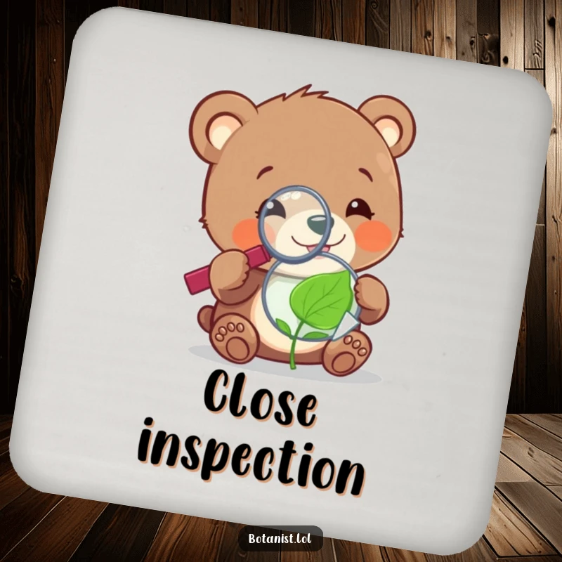 Funny cheerful bear cub with a magnifying glass, examining a tiny, sentient leaf, featured on a protective and humorous coaster.